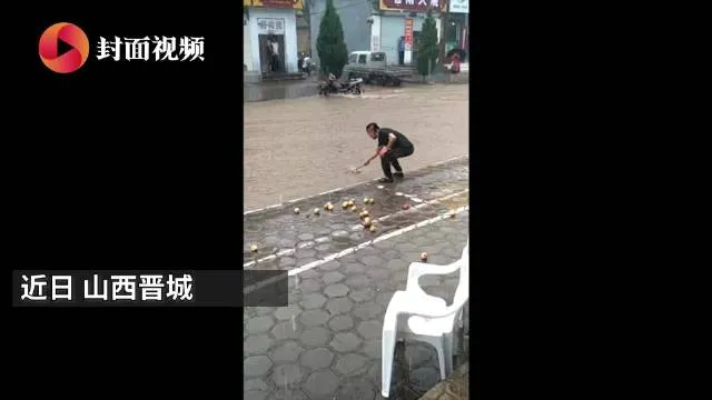 暴雨中男子用漏勺在门口捞苹果什么